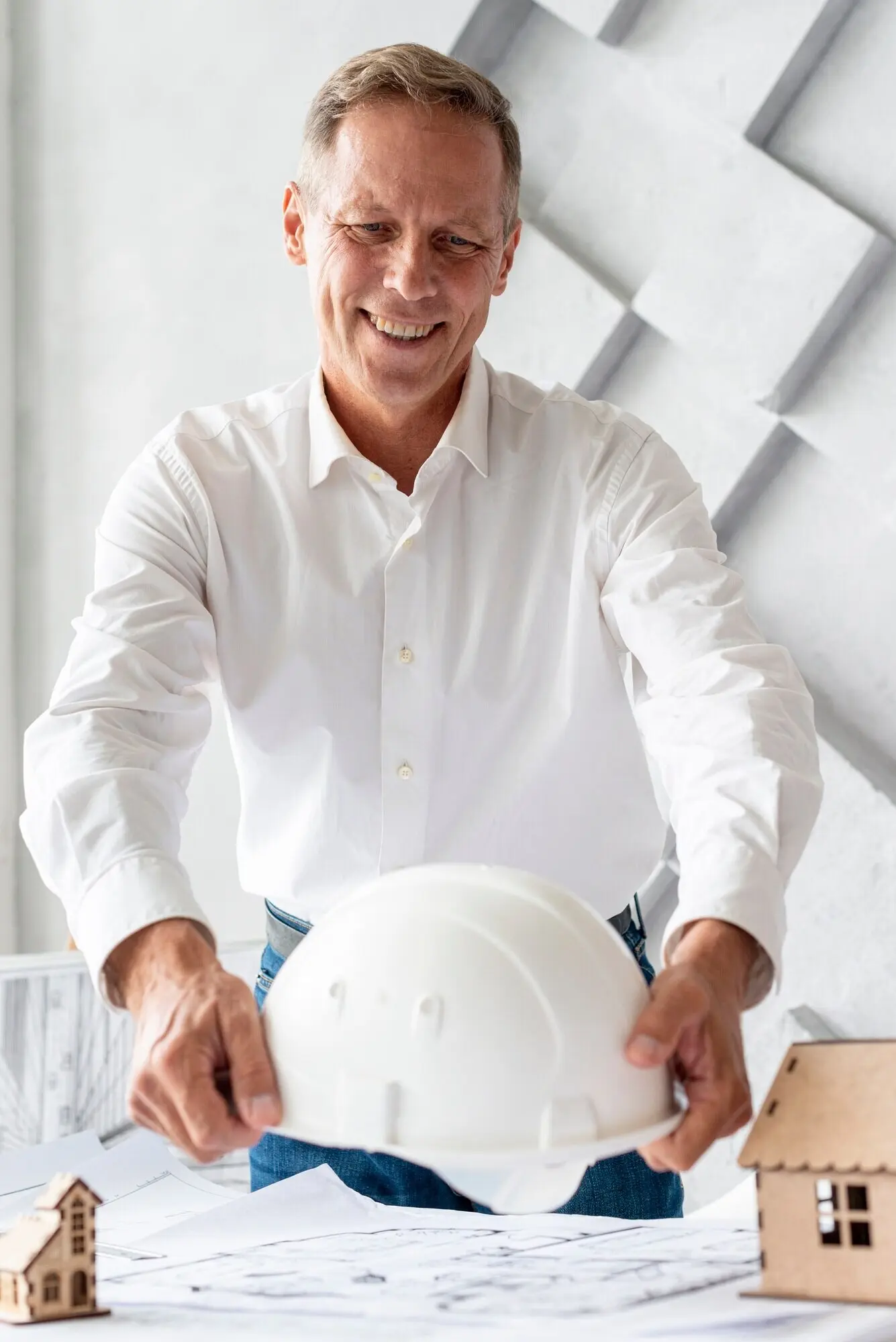 Architekt legt einen Sicherheitshelm auf den Schreibtisch.